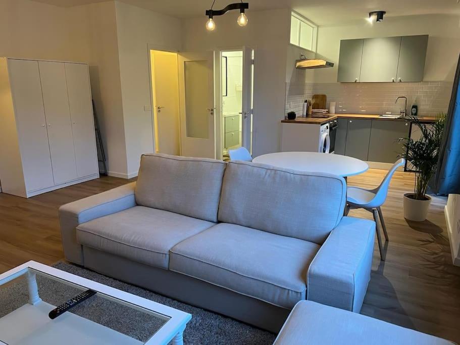 a living room with a couch and a table and a kitchen at Beautiful Flat in Etterbeek in Brussels