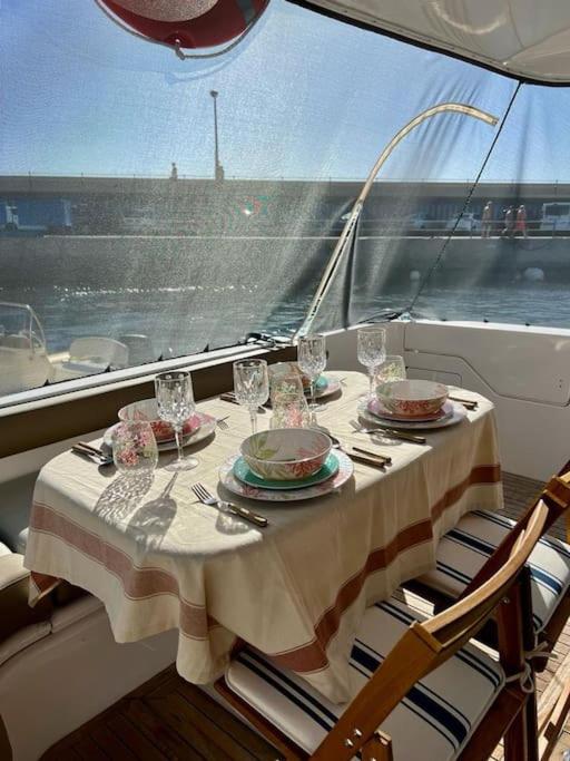 a table with plates and glasses on a boat at Yate Rumbo, casa flotante in Adeje