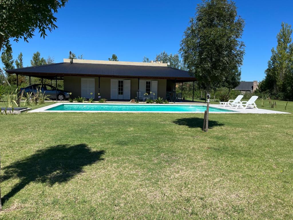 a house with a swimming pool in a yard at Casa Quinta in Mercedes