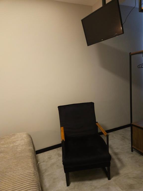 a black chair in a room with a tv at Apartamento 1 quarto em Copacabana in Rio de Janeiro