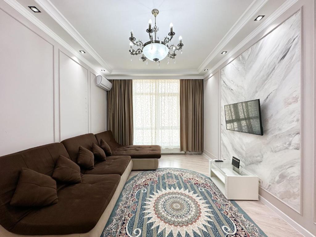 - un salon avec un canapé et un lustre dans l'établissement 2-комнатные апартаменты в жилом комплексе Zaman, à Atyraū