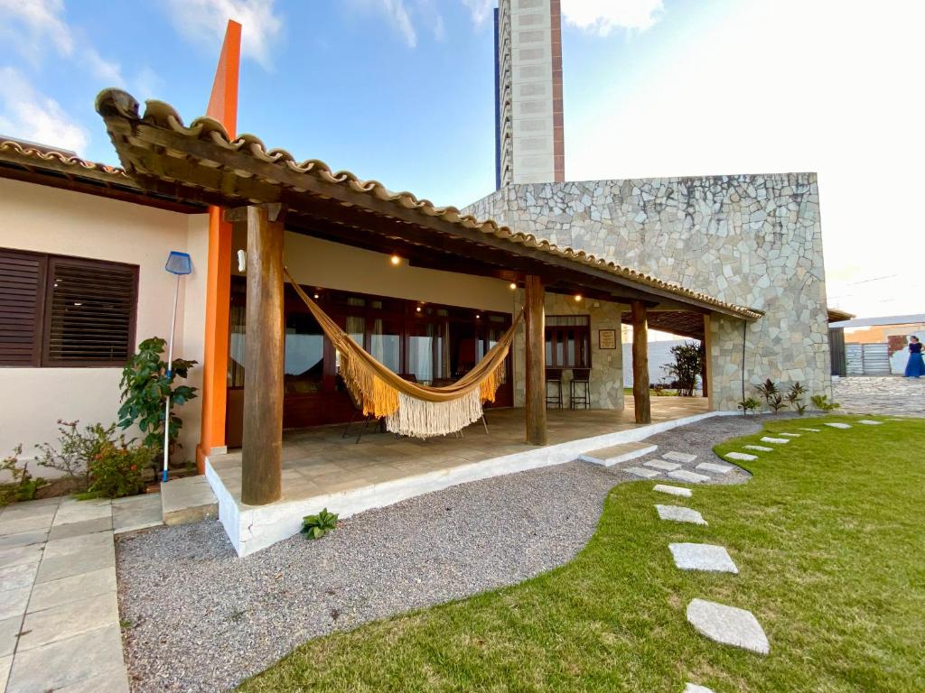 a house with a hammock outside of it at Casa Cantinho do Girassol in Natal