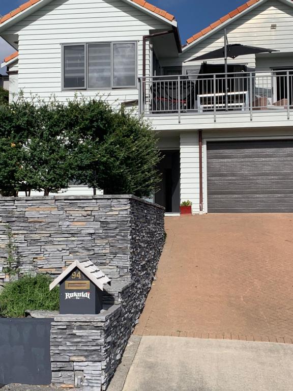 a house with a sign in front of a driveway at Te Rukutai in Auckland