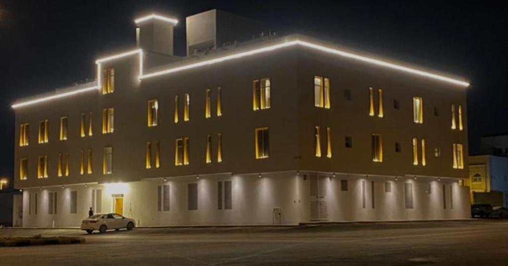 a large building with lights on it at night at أجنحة هدوء الفندقية in Riyadh