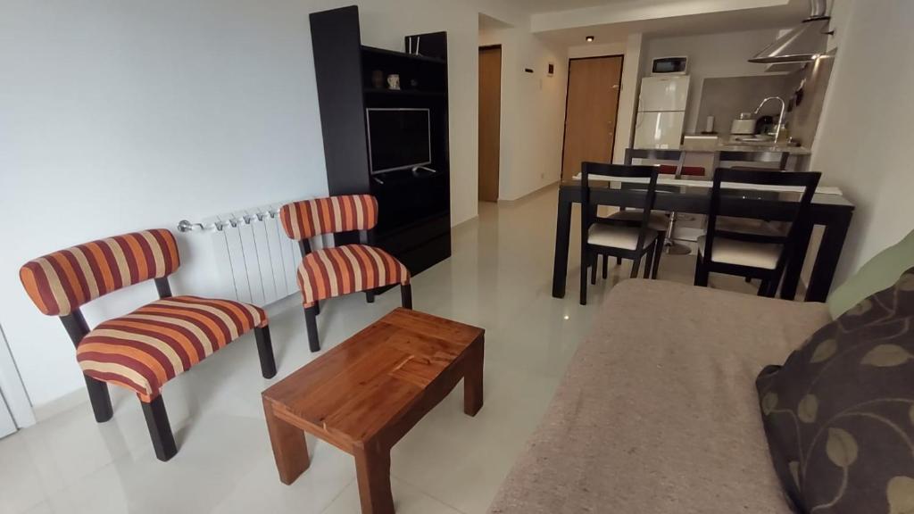 een woonkamer met stoelen en een tafel en een keuken bij Cara Sur Bariloche in Bariloche