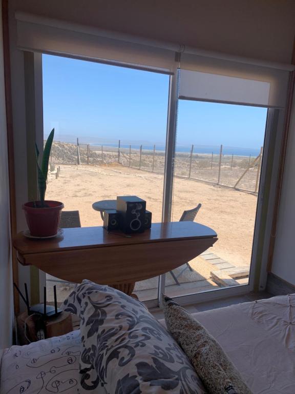 コキンボにあるHabitacion privada en Casa compartida Refugio Vida Playaのビーチの景色を望む客室で、テーブルが備わります。