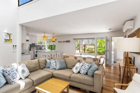 a living room with a couch and a kitchen at 5BR Modern Beach House Oasis in Cowes