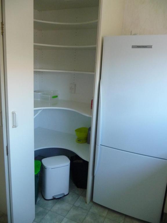 einen weißen Kühlschrank in einer Küche mit Badewanne in der Unterkunft Warm & welcome on Whiteley in New Plymouth