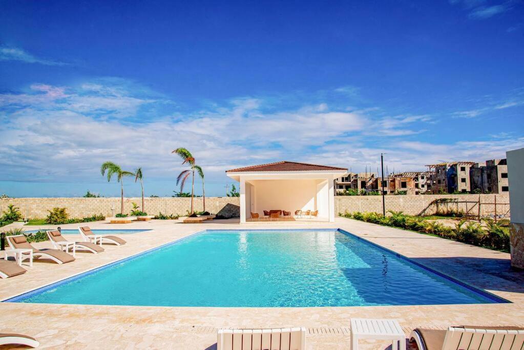 una piscina con sillas y un cenador en Beautiful Village 3 bedrooms Furnished Pool residencial Velero punta cana, en Punta Cana