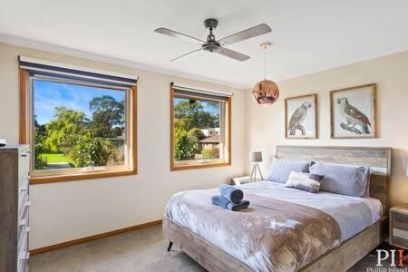 een slaapkamer met een groot bed en 2 ramen bij Private Family Home Near North-Facing Beach in Cowes
