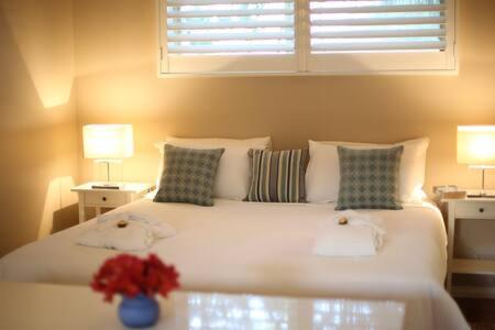 Un dormitorio con una gran cama blanca con flores. en Driftwood - Luxury Spa Cottage for Two, en Cowes