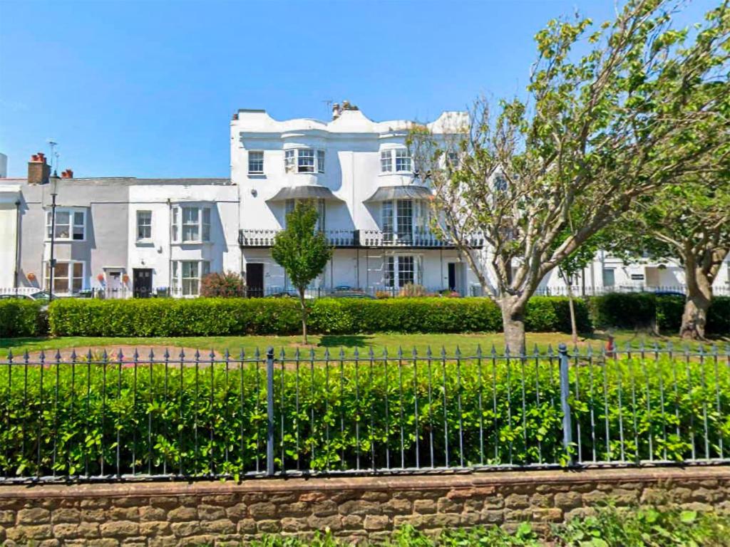 uma grande casa branca atrás de uma cerca em Seaside Retreat em Bognor Regis