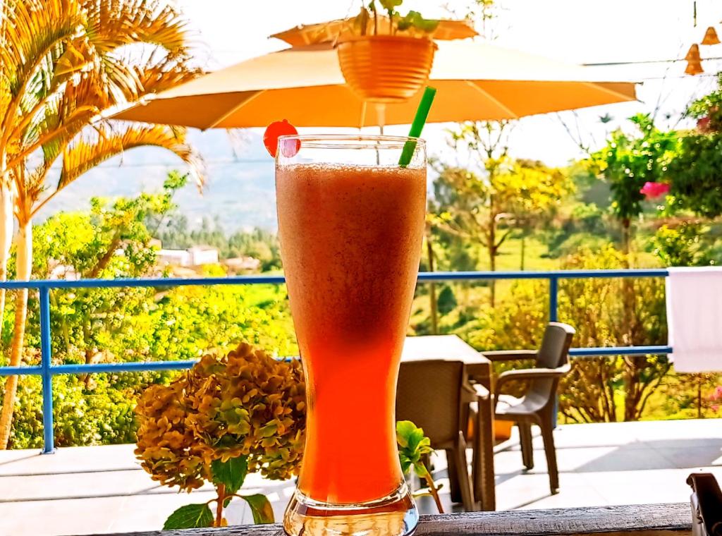 una bebida sentada en una mesa con un paraguas en ᒍᑌᕼᗩᒪᑌ, en Jericó