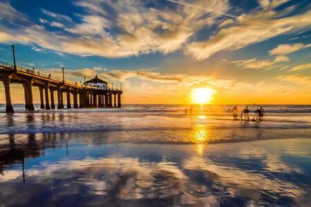 a pier with people walking on the beach at sunset at AWESOME 3BR 1 Block To Ocean Fast WIFI C1 in Newport Beach