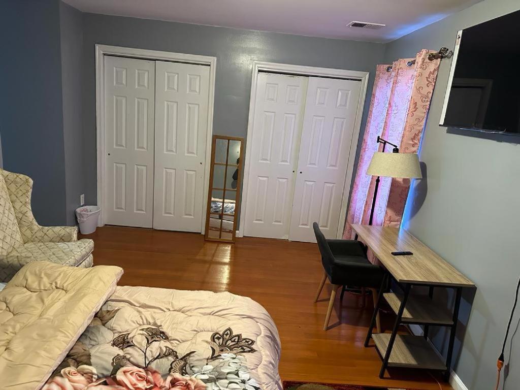 a living room with a couch and a desk with a computer at Guest House Master's Bedroom with Private Bathroom, 6 mins to Newark Liberty International Airport Penn Station Prudential New York It is central close to major places in Newark