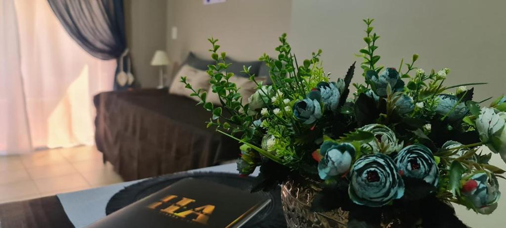 a vase filled with blue flowers on a table at Humberto Apart A in Luján