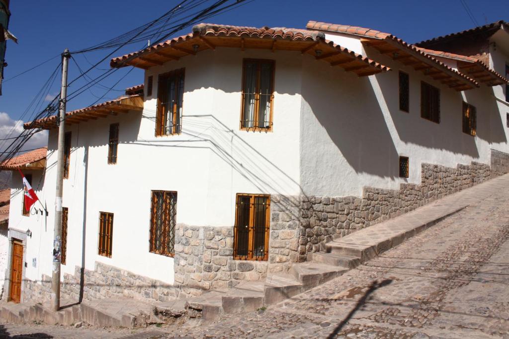 uma casa branca com uma parede de pedra em Maison Fortaleza em Cusco