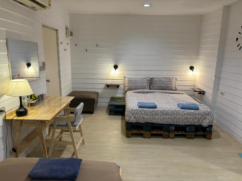 1 dormitorio con cama y mesa de madera en La Locanda, en Bangkok