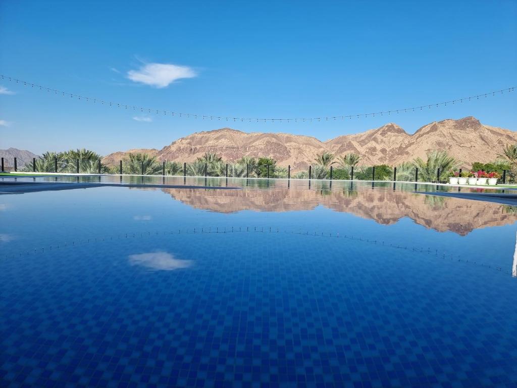 a view of the water with mountains in the background at Sheema Lodge in Hatta