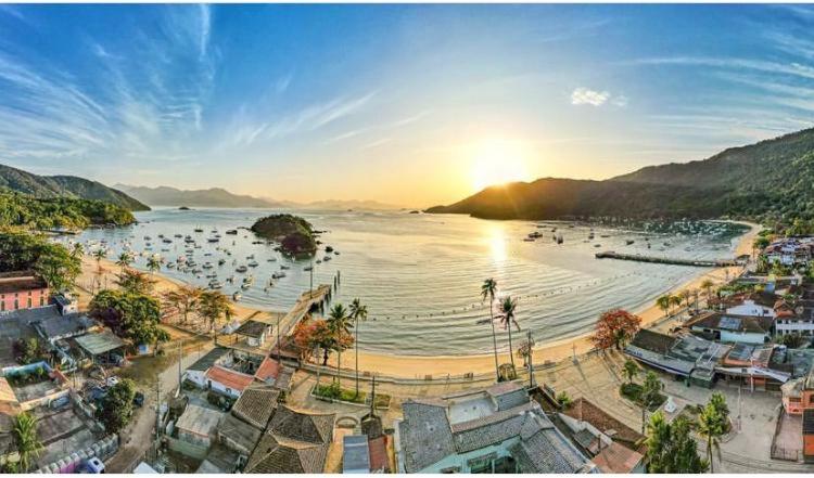 un grupo de personas en el agua en una playa en Descanso do Jordão en Ilha Grande