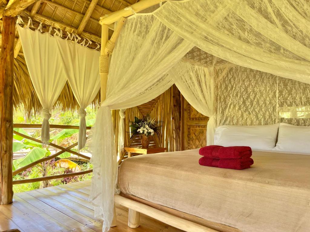 a bedroom with a bed with a canopy at Treehouse waterfalls El Limón D-03 in El Limón