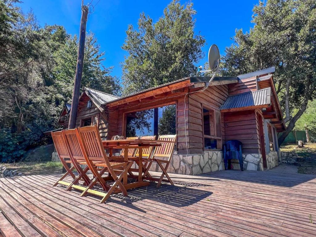 een hut met een houten tafel en stoelen op een terras bij Casa Buena Vista in Bariloche