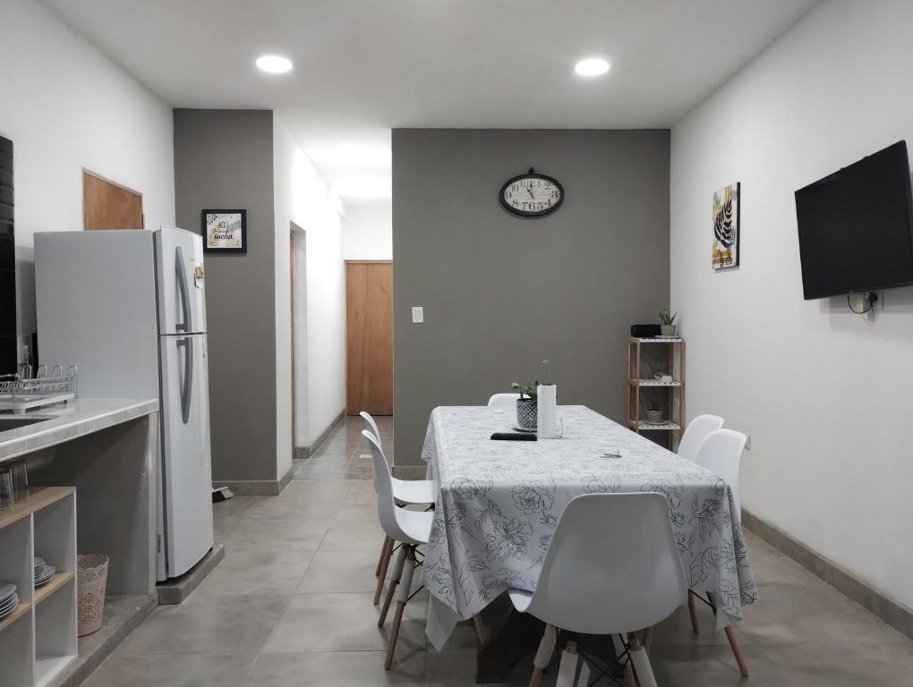 een keuken met een tafel met stoelen en een koelkast bij Nanai in Cafayate
