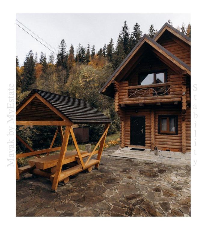 a log cabin with a porch and a balcony at Mayak Chalet Resort Mykulychyn in Mykulychyn