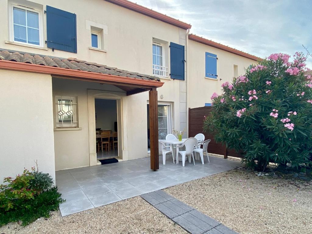 Cette maison dispose d'une terrasse avec une table et des chaises. dans l'établissement Maison Bretignolles-sur-Mer, 3 pièces, 4 personnes - FR-1-231-146, à Bretignolles-sur-Mer