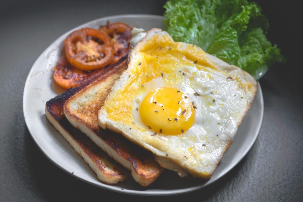 a plate of breakfast food with an egg and bacon at Sea View Villa in Hikkaduwa