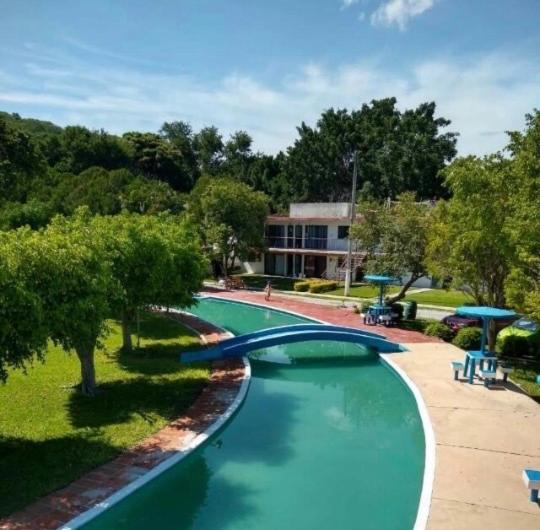 Ticumán的住宿－Casita en Ticuman，公园里一个带蓝色滑梯的游泳池