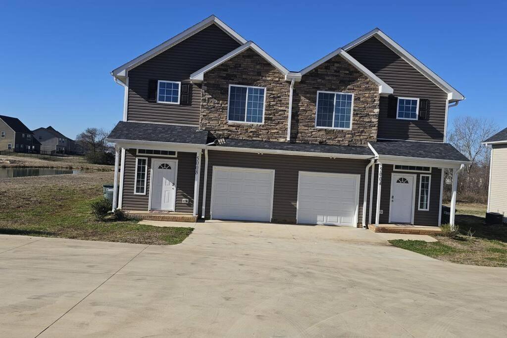 a house with a black roof and a garage at Spacious 3-Bedroom Modern Home Near CLT Motor Speedway in Concord