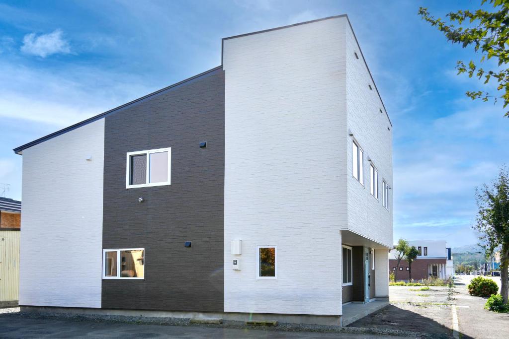 a house with a black and white facade at FuranoSky - White in Furano