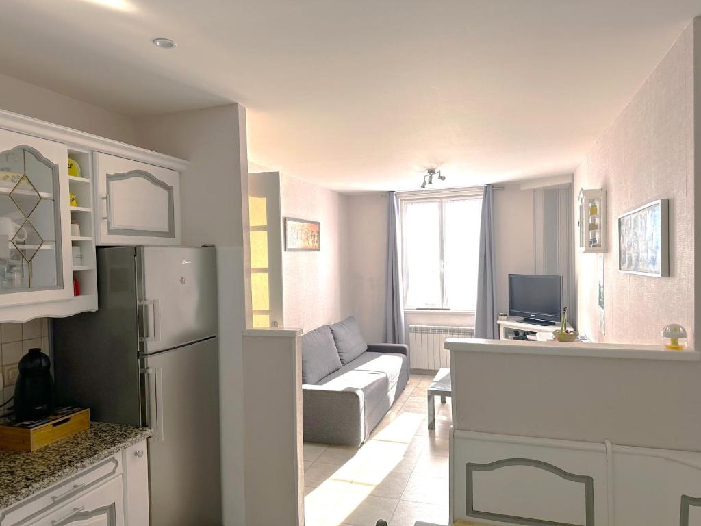 uma cozinha e sala de estar com um frigorífico e um sofá em Appartement Hendaye, 3 pièces, 6 personnes - FR-1-239-1018 em Hendaye