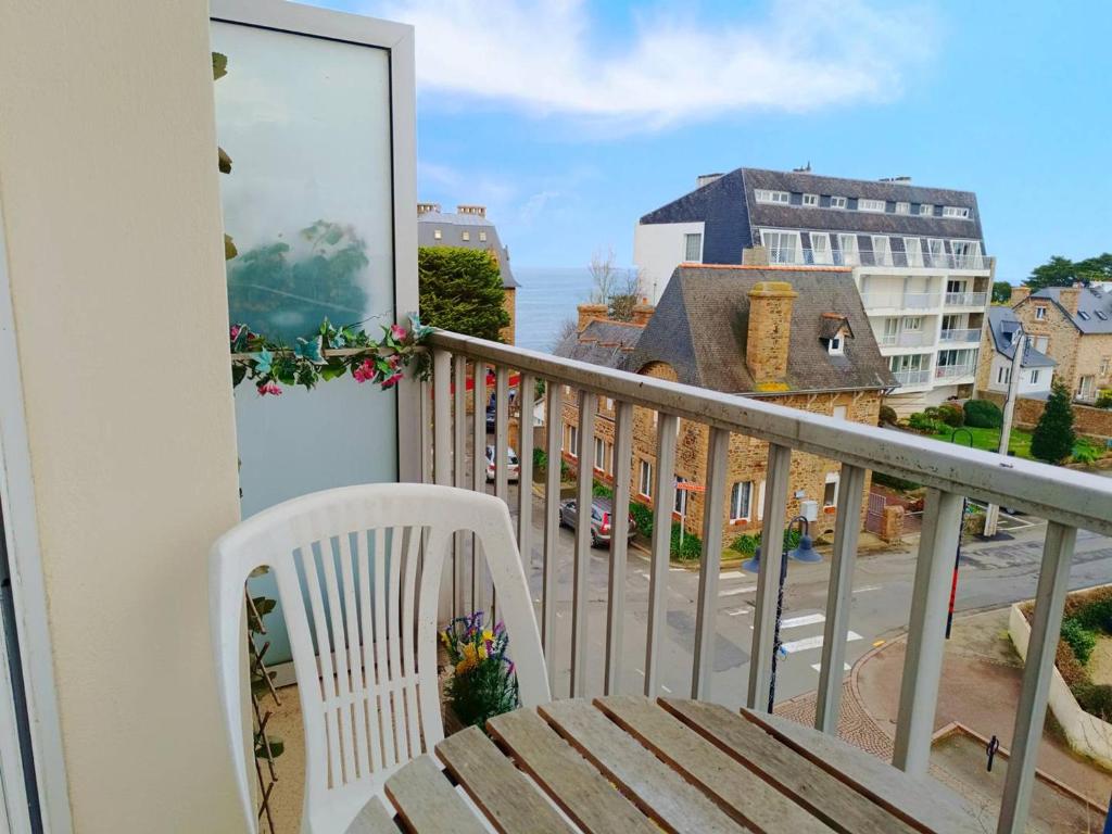 d'un balcon avec une chaise blanche et une vue sur la rue. dans l'établissement Appartement avec WIFI, au centre-ville de Perros-Guirec - FR-1-368-406, à Perros-Guirec