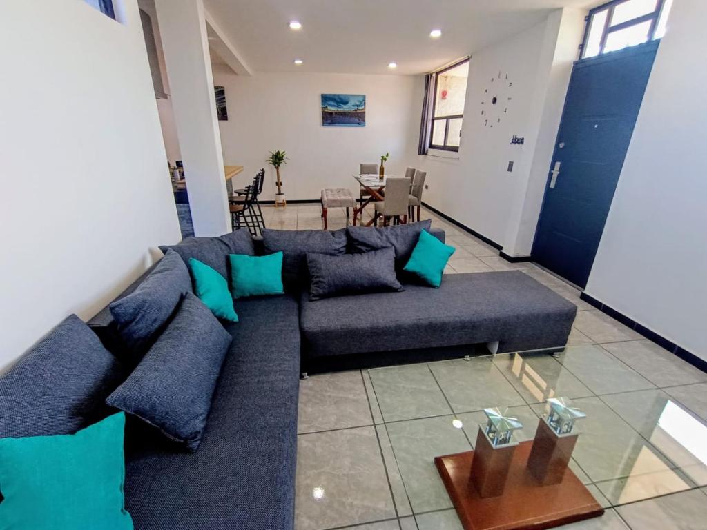 a living room with a blue couch and a table at Departamento Nuevo Suite Máster in Aguascalientes