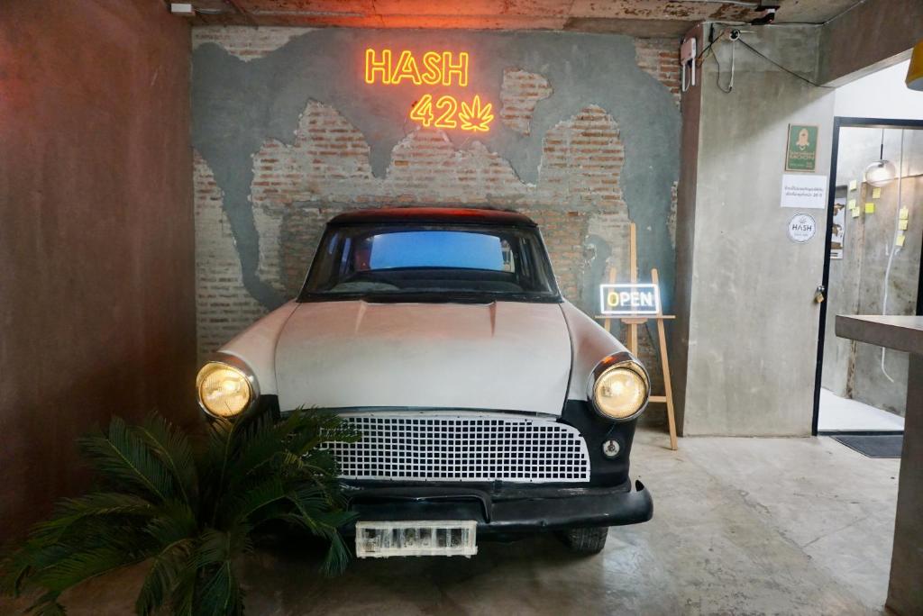 een oude auto staat geparkeerd in een garage bij Chill apartment with unique design @ Silom Soi 3 in Bangkok