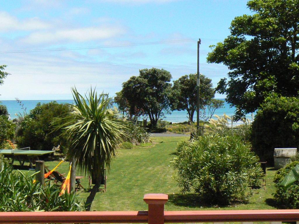 a view of a park with the ocean in the background at Endless Summer Lodge in Ahipara