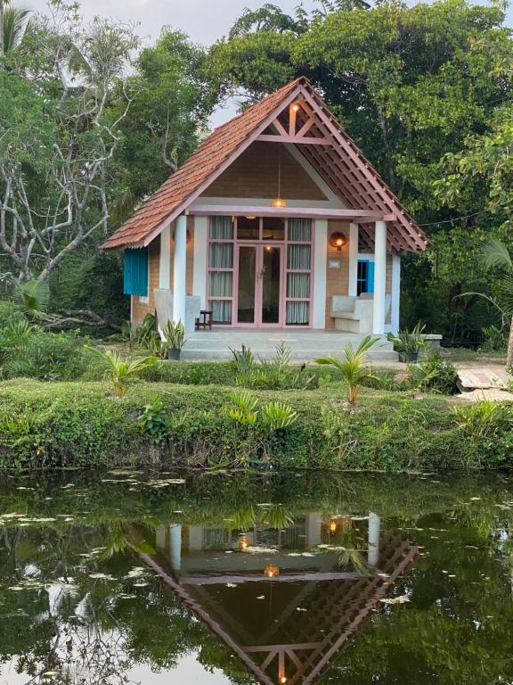 a small house next to a body of water at Summer Bell Midigama in Midigama East
