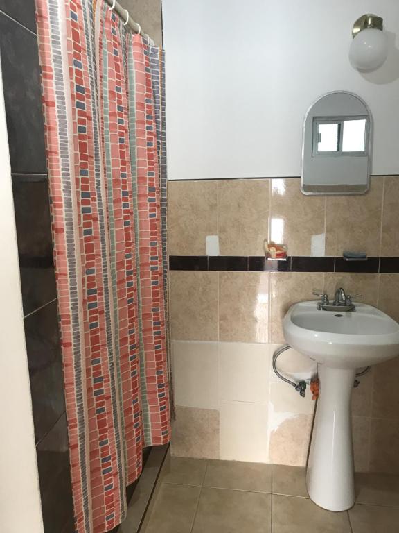 een badkamer met een wastafel en een douchegordijn bij Habitacion #1 in Chihuahua