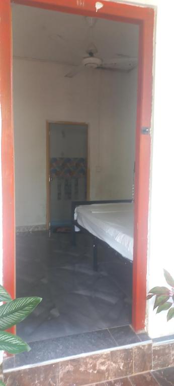 Zimmer mit einem Bett in einem Zimmer mit Tür in der Unterkunft Singleroom in Trincomalee
