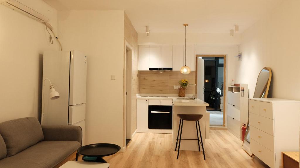 eine Küche und ein Wohnzimmer mit einem Sofa und einem Kühlschrank in der Unterkunft Shanghai Hills & CoZy Roof House in Shanghai