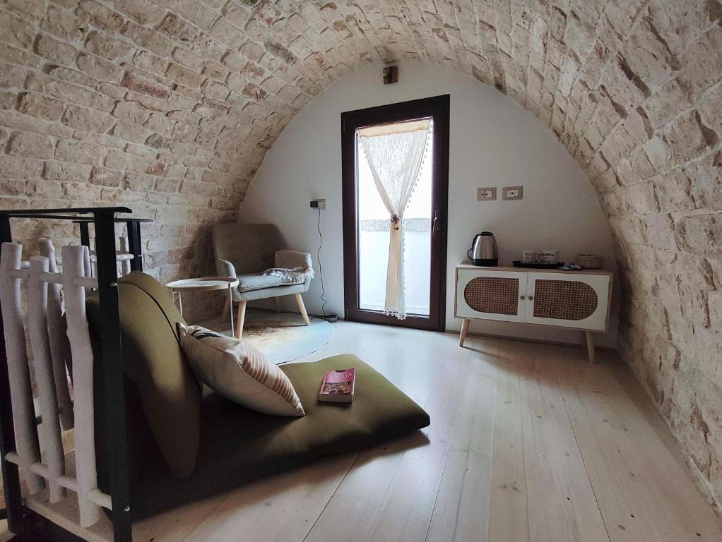 a living room with a brick wall and a window at Archi Antichi in Putignano