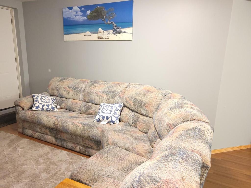 a couch in a living room with two pillows on it at Cozy 2-Bedroom Basement Suite Retreat Calgary in Calgary
