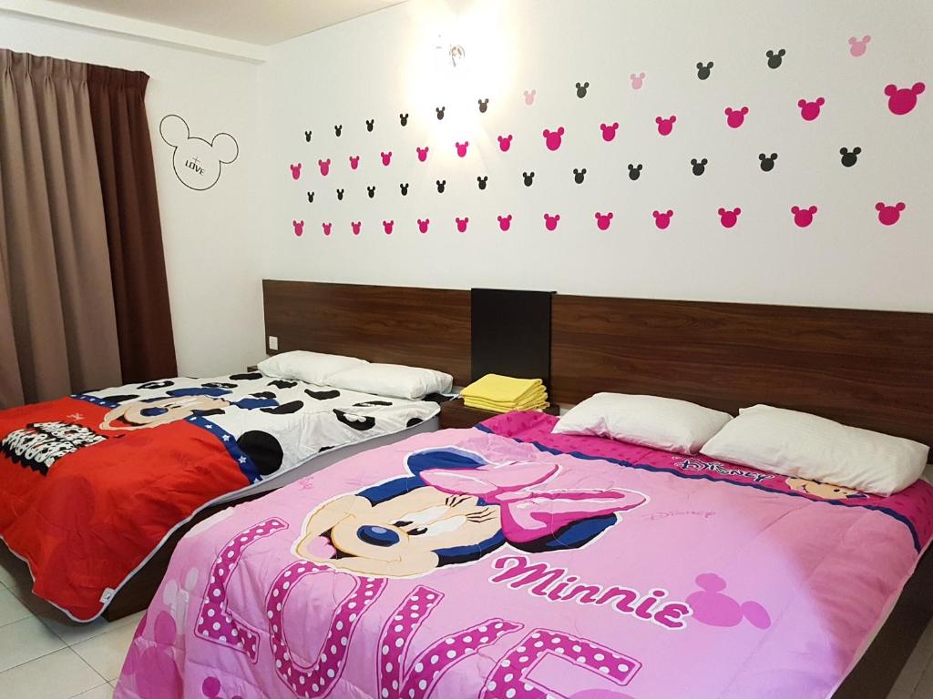 - une chambre avec 2 lits avec des cœurs sur le mur dans l'établissement Sunshine Lot 10 Pangkor, à Kampong Sungai Udang