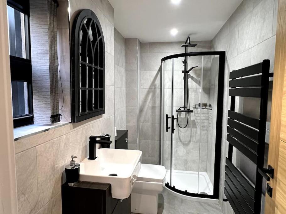 uma casa de banho com um lavatório e um chuveiro em Hospital View Apartment em Glenfield