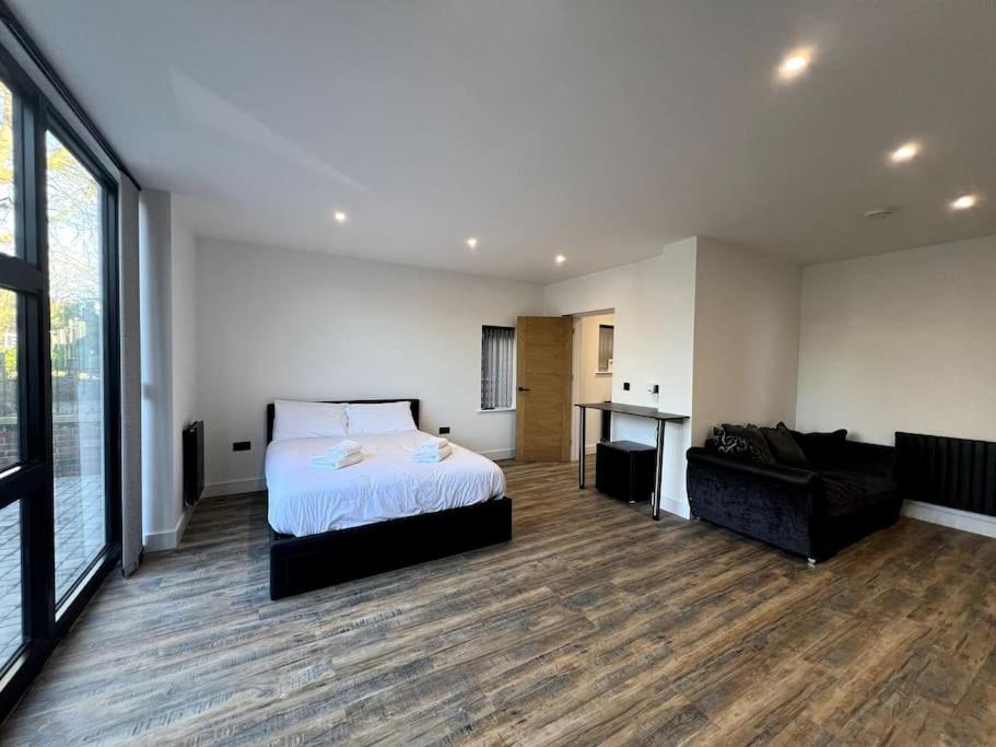 a large bedroom with a bed and a couch at Modern Studio Apartment Near Glenfield Hospital in Glenfield