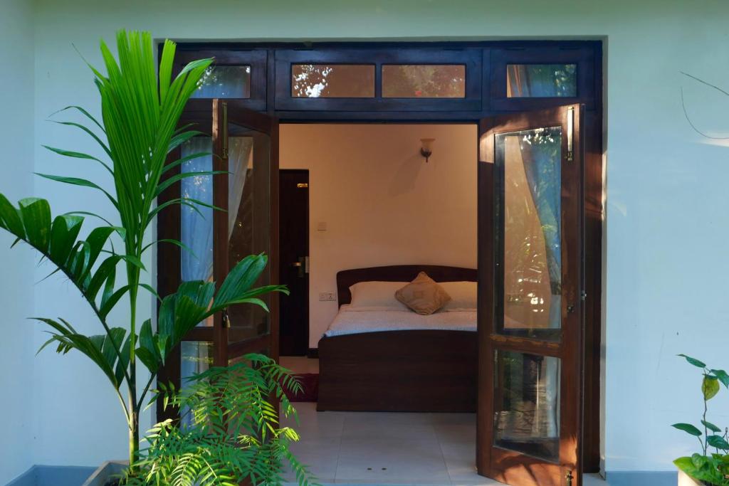 1 dormitorio con 1 cama y algunas plantas en The Bliss Hostel Kandy en Kandy