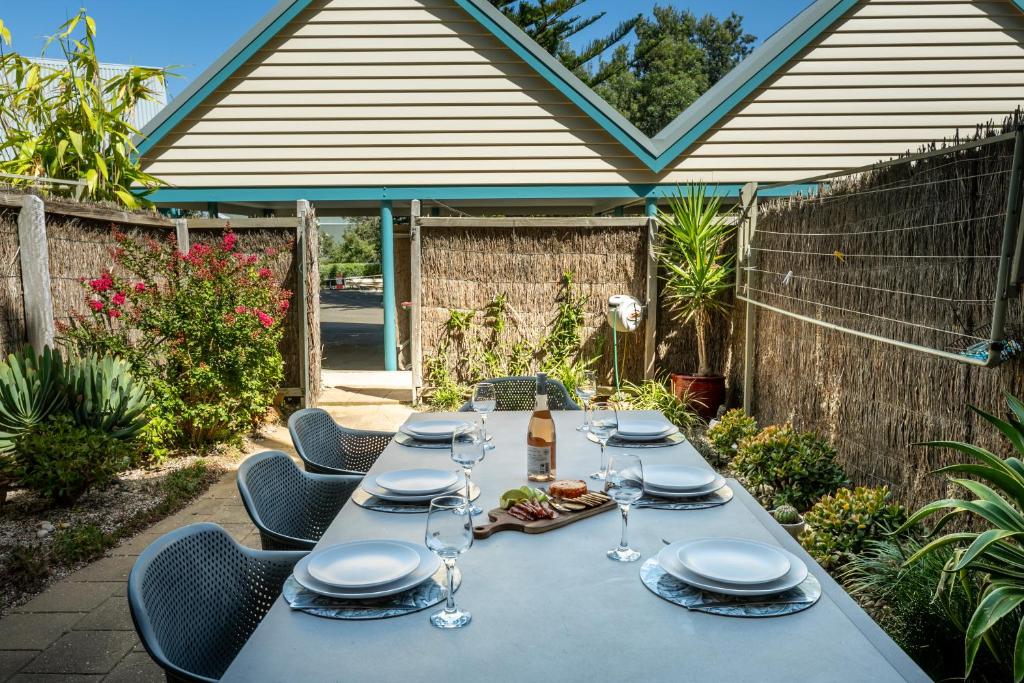 una mesa larga con platos y copas de vino. en The Dunes, en Ocean Grove