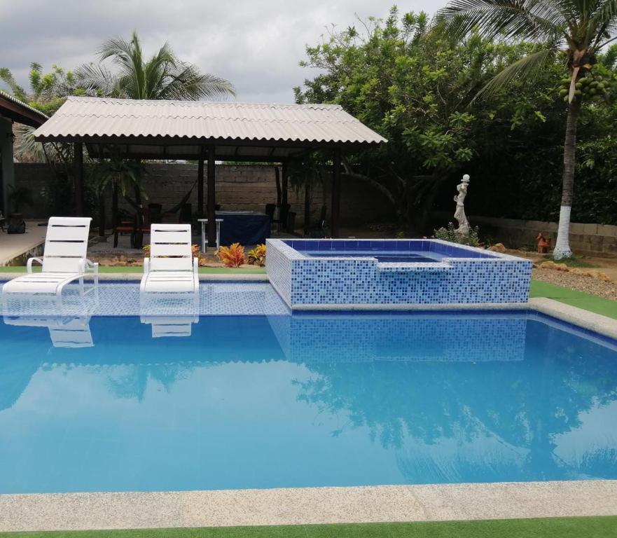 einen Pool mit zwei Stühlen und einem Pavillon in der Unterkunft Espectacular Cabaña en Santa Veronica in Santa Veronica
